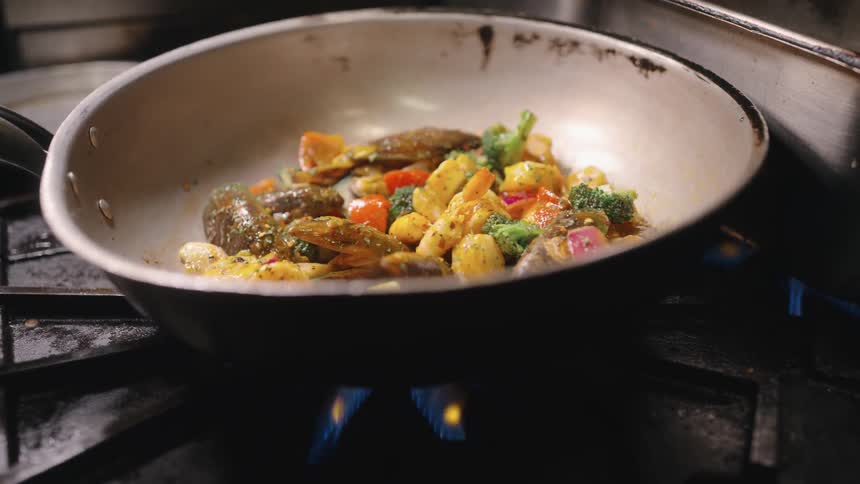 Food is cooking in the pan on the stove