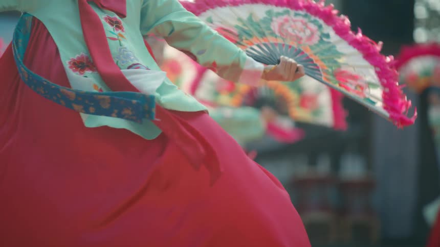 Women in ornate period korean costumes dance with fans