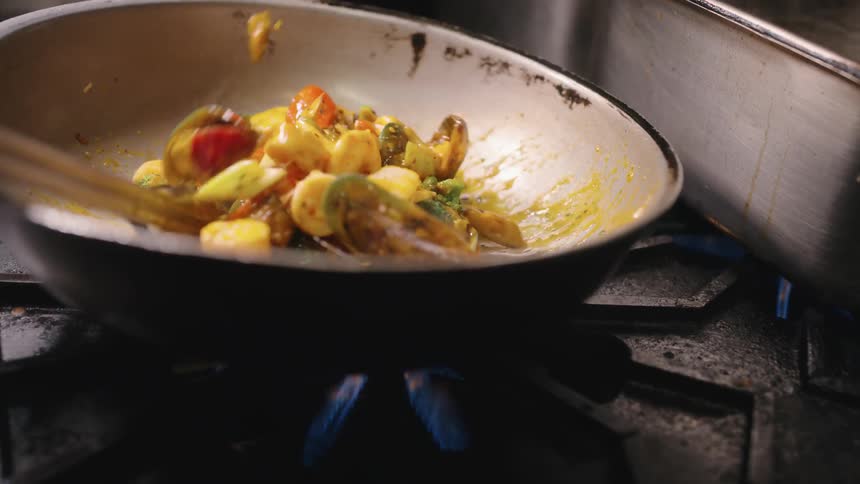 A person is stir frying a meal
