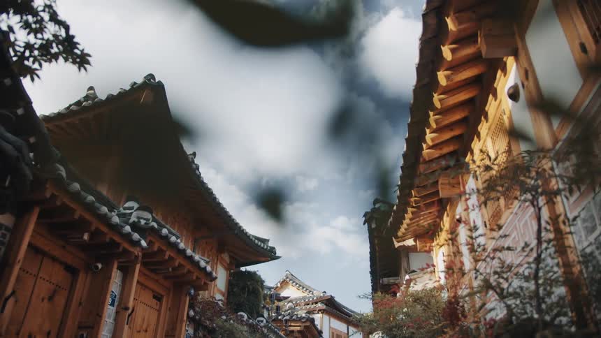 Heavy clouds hover over ornate roofed and decorated buildings