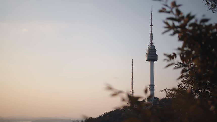 A pointed tower on a hill in the evening