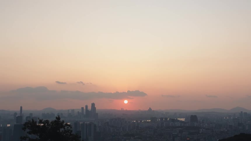 Sun rises on horizon over fog covered city