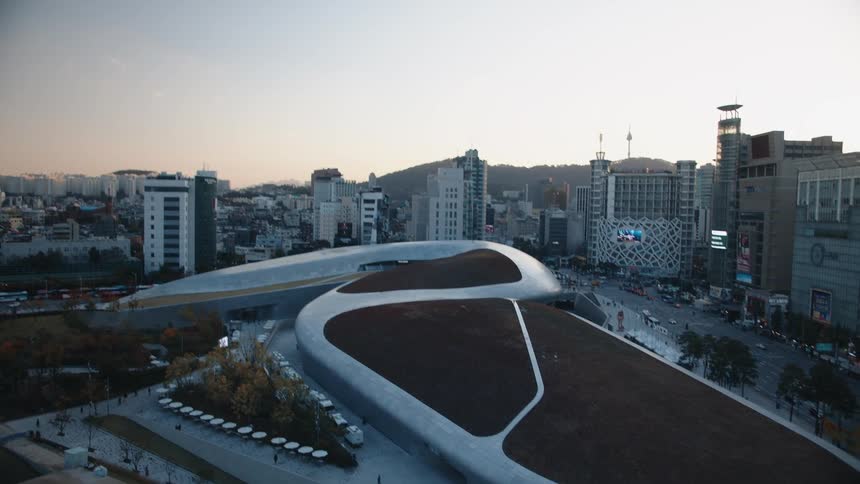 Flowing building architecture among low rise buildings near mountains