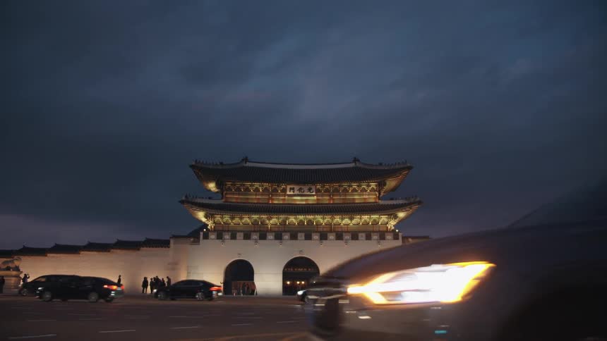 Vehicles drive past a traditional style of asian architecture