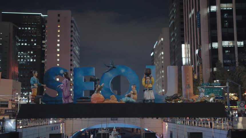 Cars drive by a sign for seoul