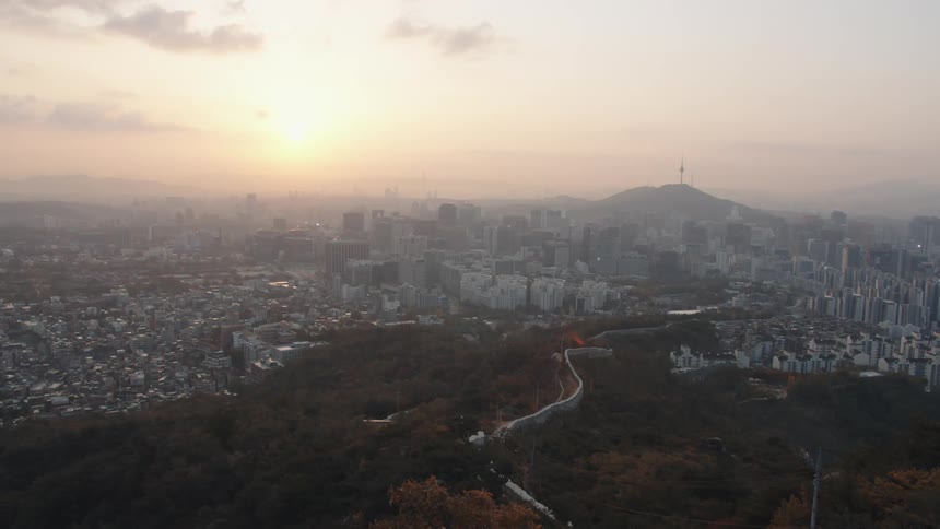 The sun sets over skyscrapers and buildings in a city