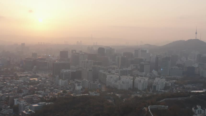 The sky above a dense city is filled with smog