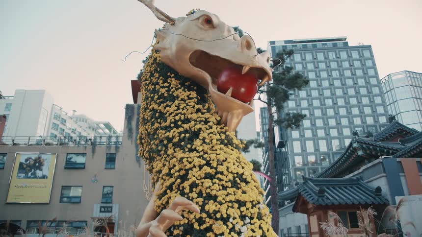 A dragon sculpture in a city with eastern architecture