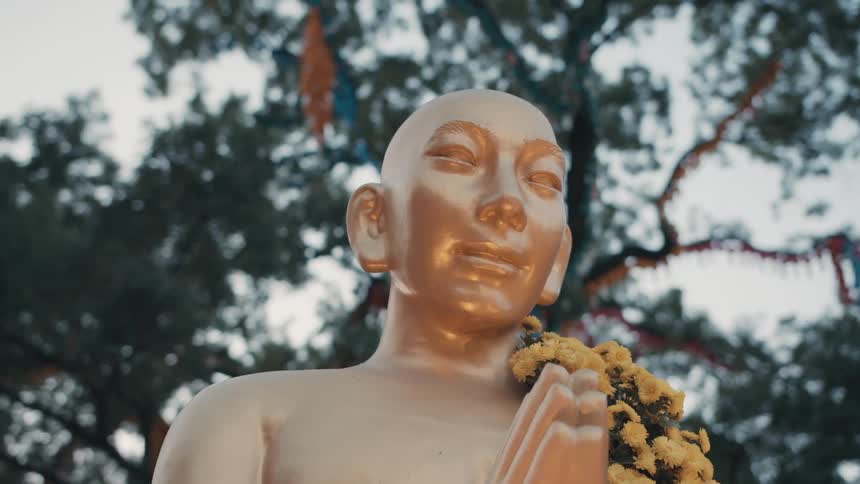 A golden statue sits under the trees