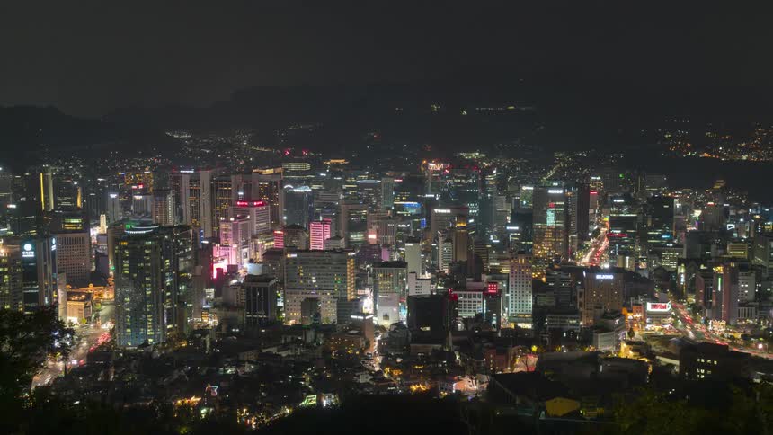The skyline of a large city full of skyscrapers and traffic at night