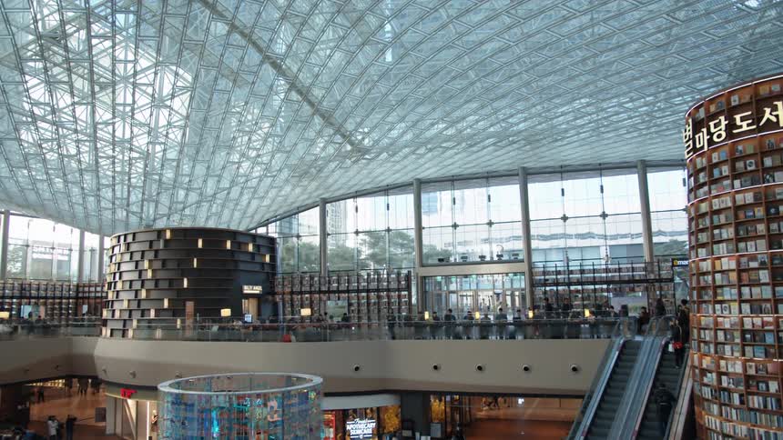 A shopping center with a glass ceiling during the day