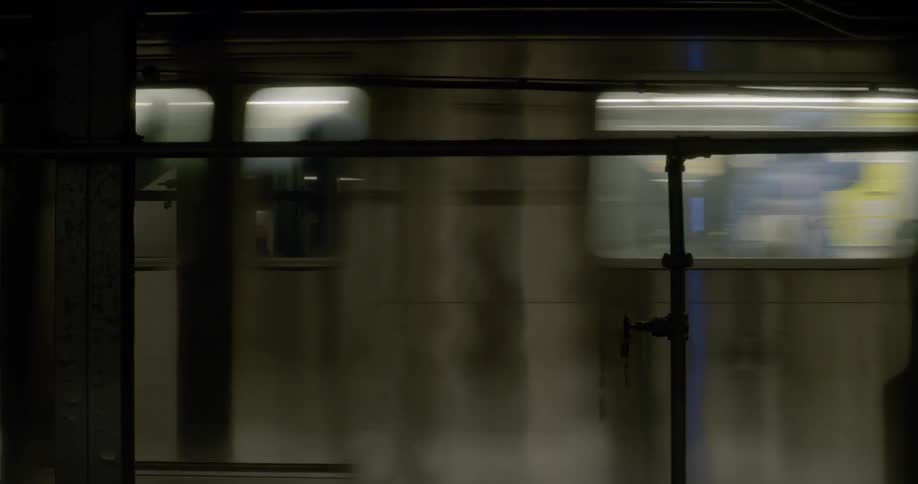 An underground subway passing people on a subway platform
