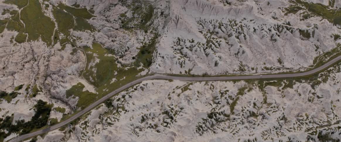 Aerial view of pink hued mountains with a road between them