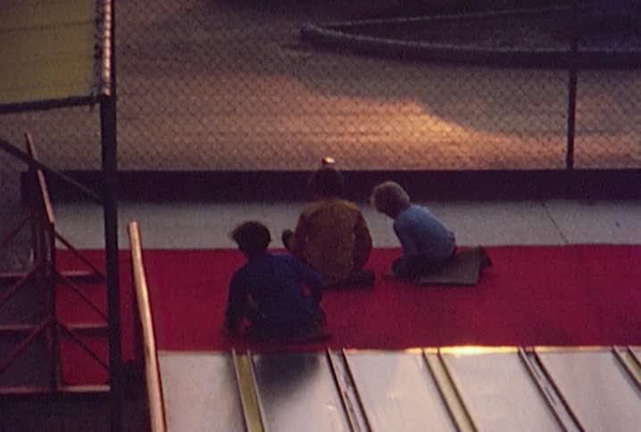 Young boys sliding down a large amusement park slide