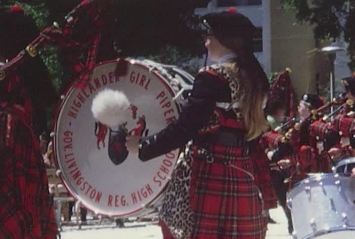 Uniformed bagpipers, drummers and dancers entertain a seated crowd