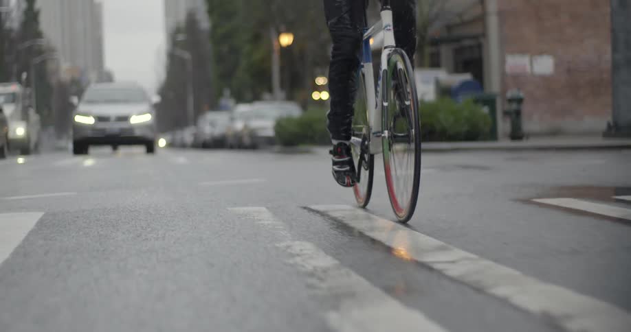 A bicycle traveling on a city street on a rainy day