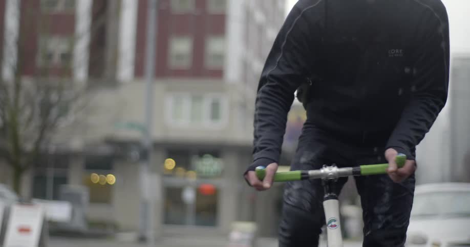 A man rides a bike on a rainy day