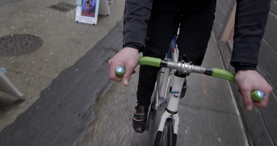 Person riding a bike with green handle bars