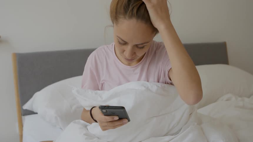 A woman sits on her phone