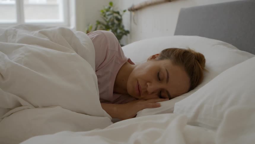 A woman sleeps in bed