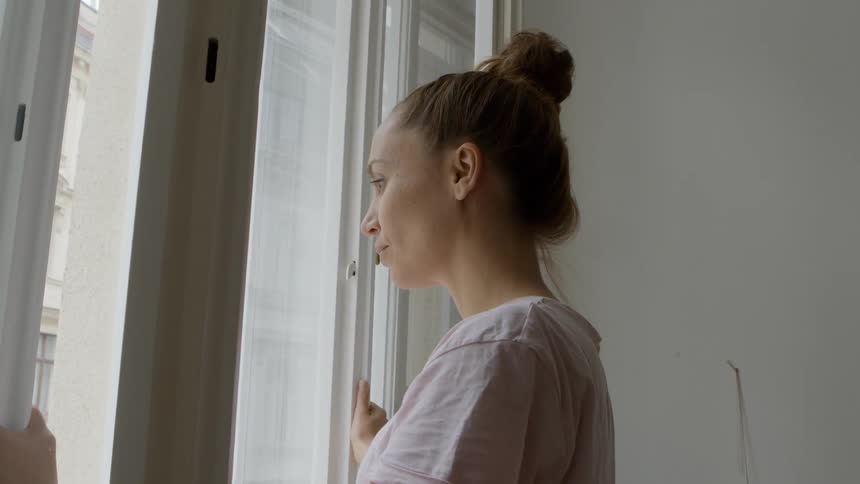 A woman looks out the window