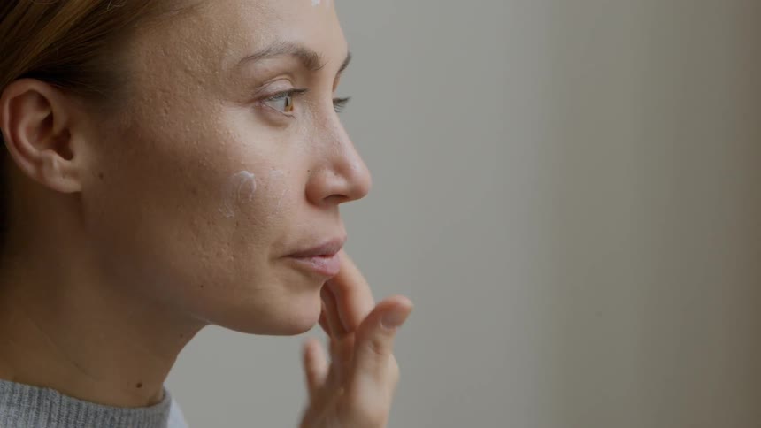 Close up of a woman applying moisturizer on her face