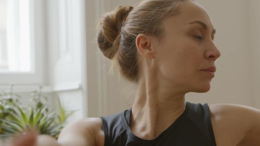 A woman doing yoga in a house during the day
