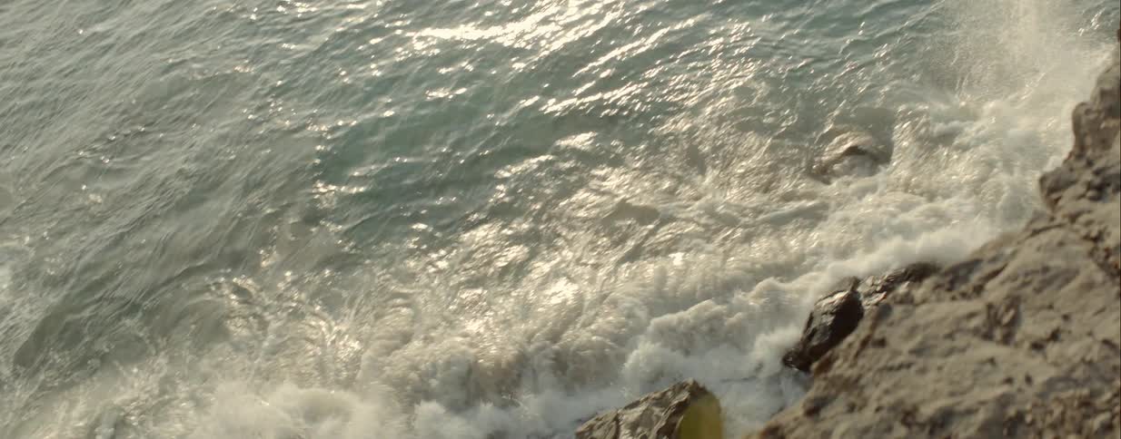 Ocean waves roll over the rocks towards the shore