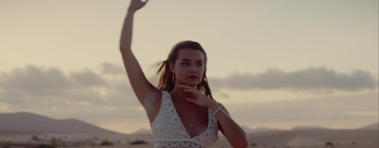 A young white teenager dances in a field with horses