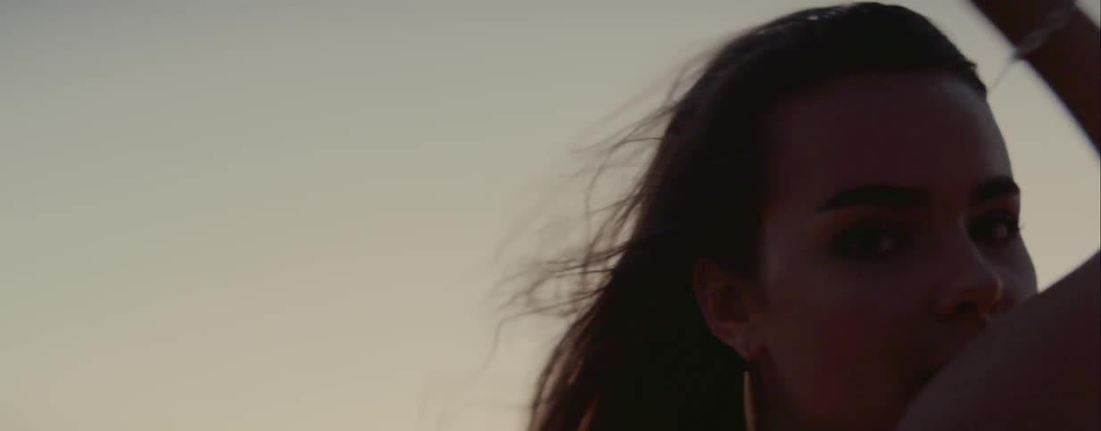 A woman dances outside with the wind blowing