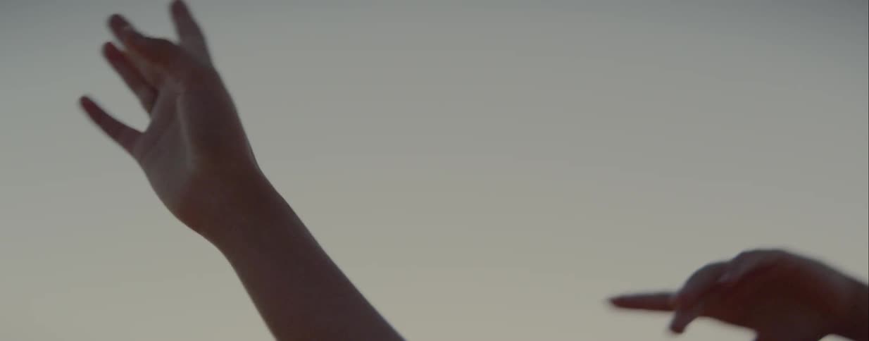 A womans hands turn and dance above her head