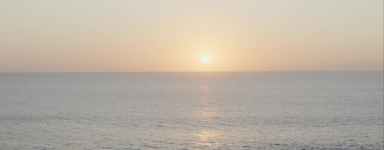 Sea ripples near shore as sun reflects off ocean
