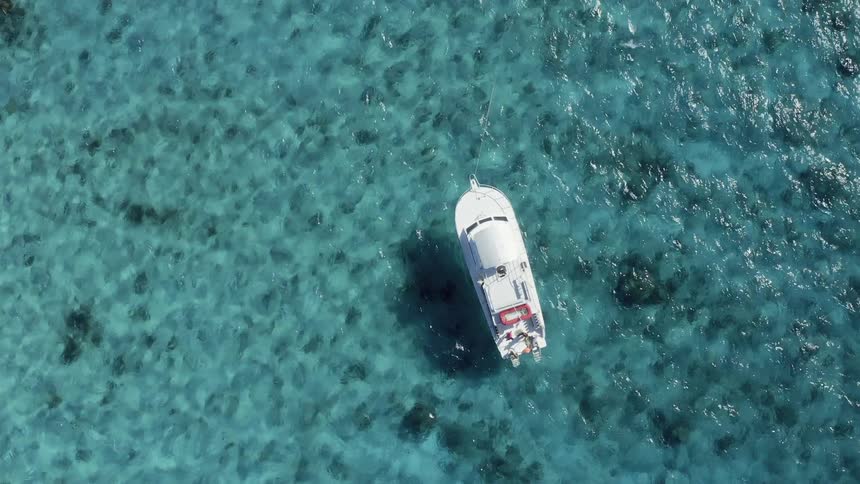 A boat floats on the clear water