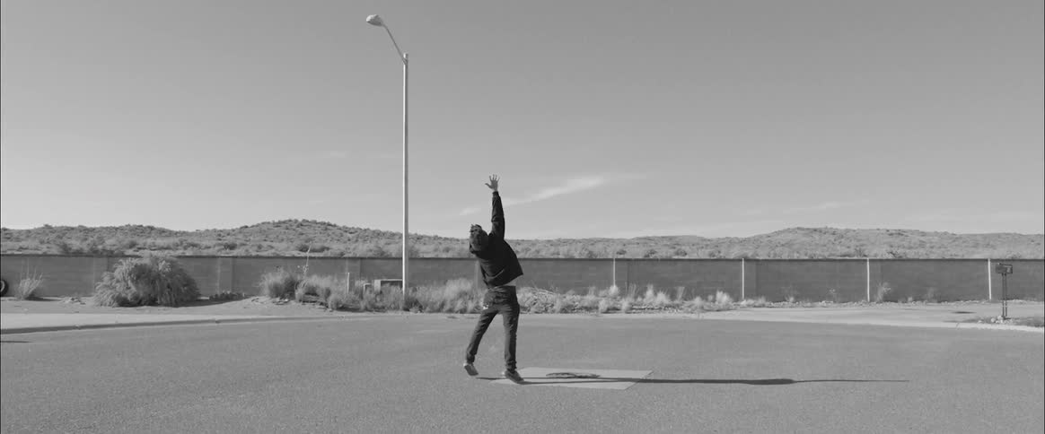 A man reaches up and waves his arms towards the ground