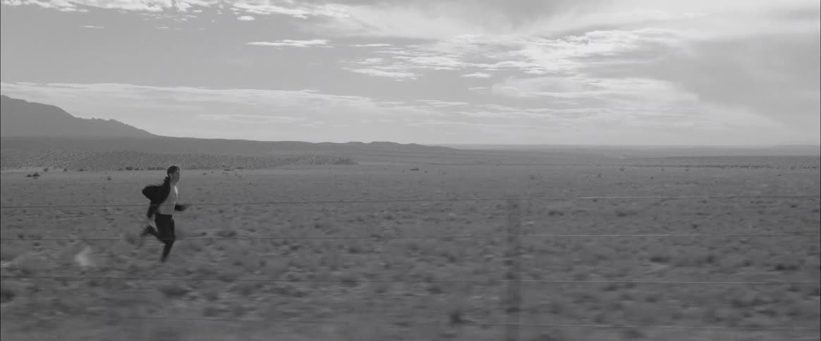 A male teenager runs across a field