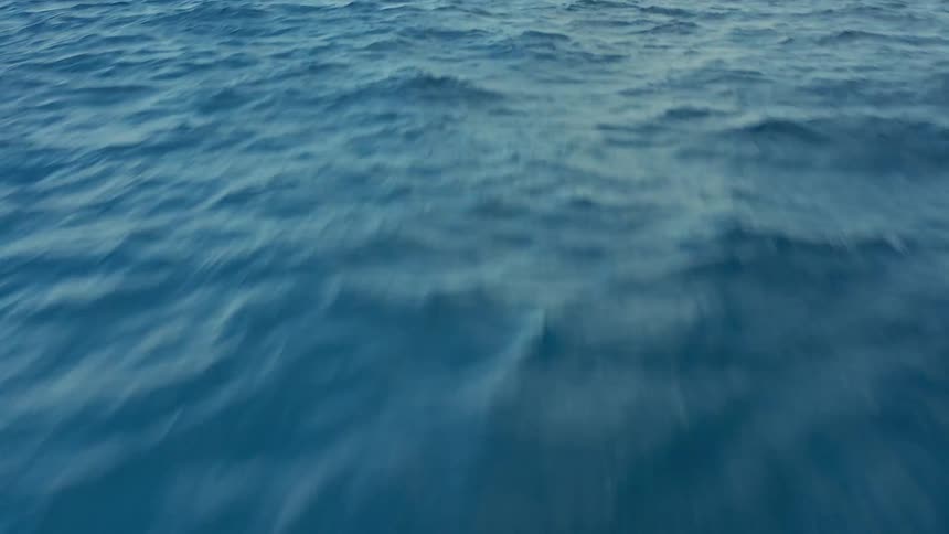 The shore is visible in the far distance from the ocean