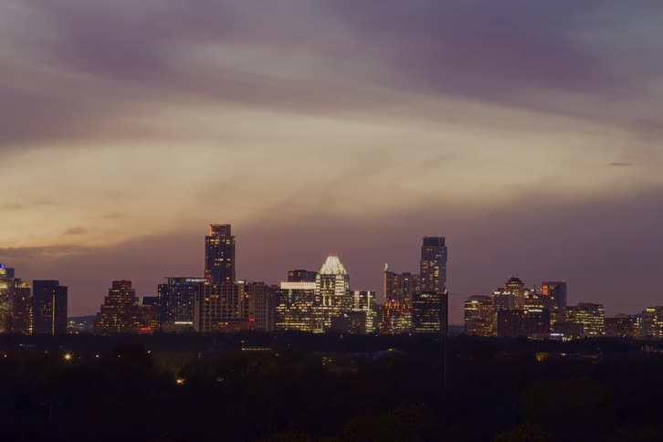 Clouds move over the city as night falls