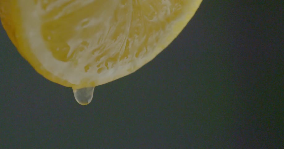 Juice drips from sliced lemon