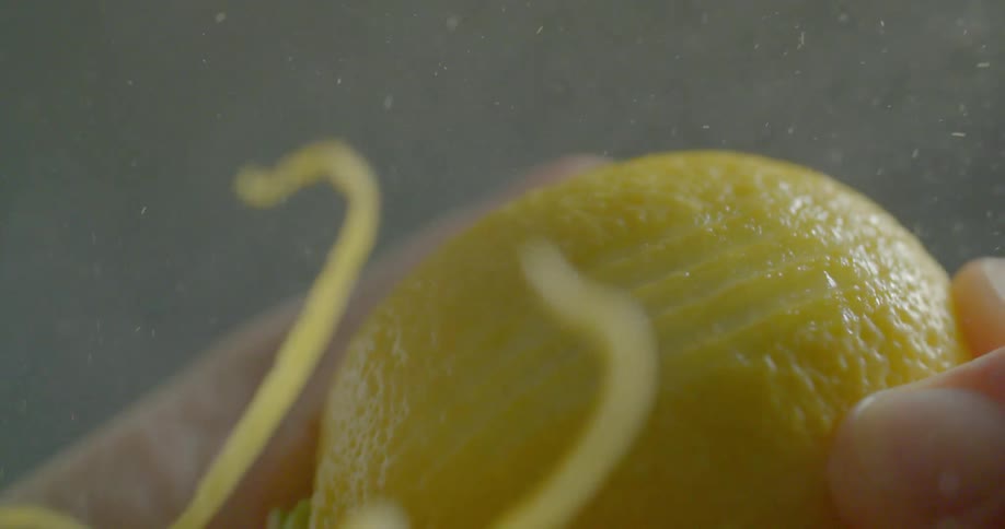 A person runs a zester over a lemon