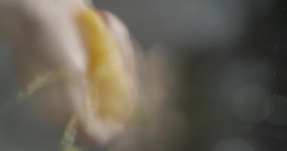 A person squeezes an orange half