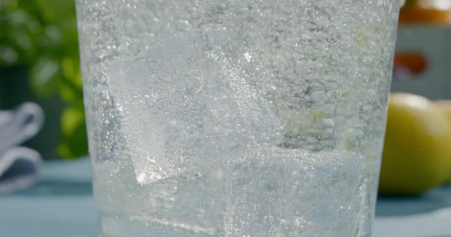 Ice cubes and bubbles float in a beverage