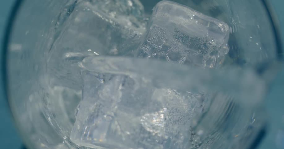 A beverage is poured into a glass of ice