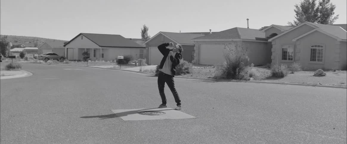 A young boys stands in the street and sings