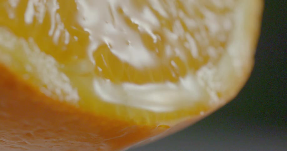 Juice flows down surface of sliced orange
