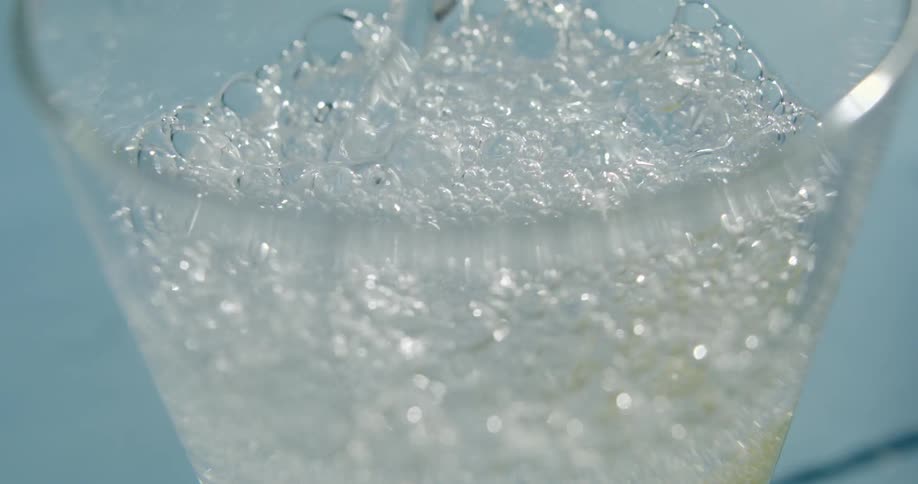 The glass is being filled with liquid