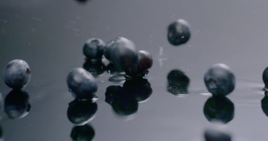 Blueberries dropping on to a wet surface