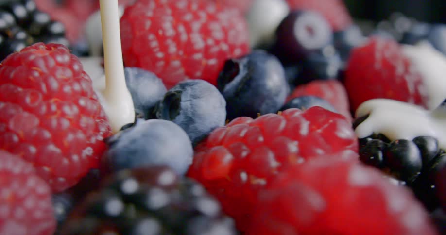 Cream is being poured over a bowl of spinning berries