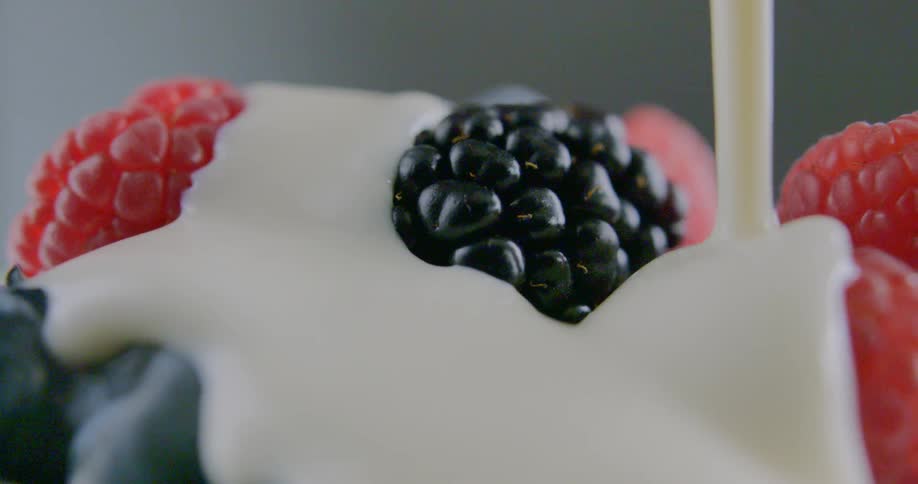 Cream is being poured on fruit