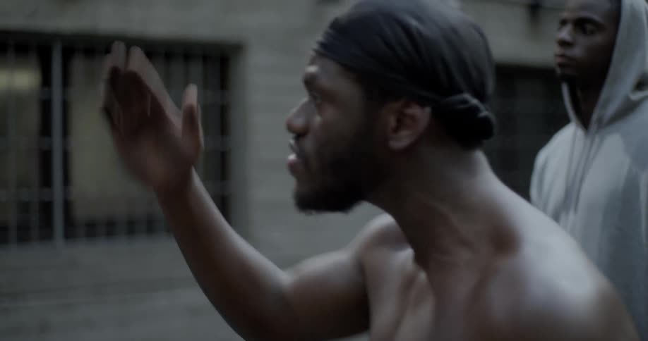 Man yells at and shove another near building with barred windows