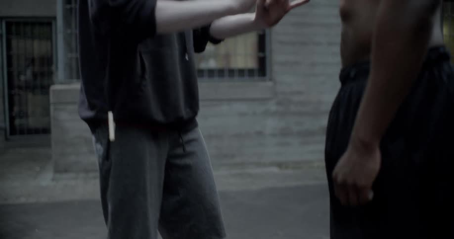 A large basketball player shoves a smaller guy